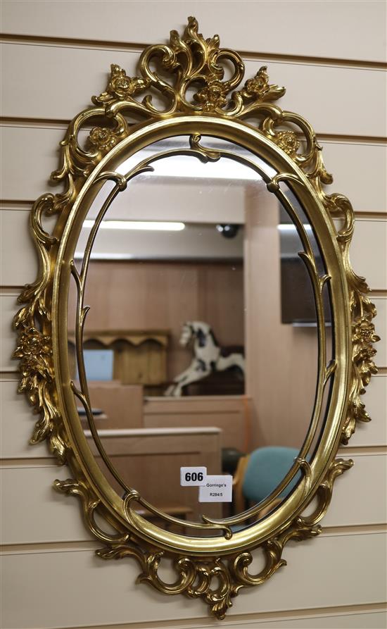 An ornate oval gilt framed wall mirror, W.75cm